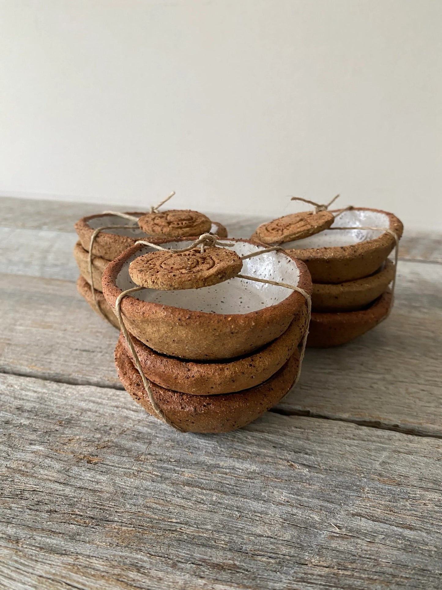 A set of 3 small hand formed trinket bowls. Rustic clay with speckled white glaze.  (6-01)